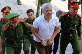 Lực lượng chức năng dẫn giải bị cáo Nguyễn Văn Khuê vào phòng xét xử. (Ảnh: Vũ Hà/TTXVN)