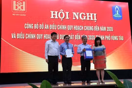 Đại diện Bộ Xây dựng trao Quyết định, tài liệu điều chỉnh quy hoạch cho lãnh đạo tỉnh Bà Rịa-Vũng Tàu và thành phố Vũng Tàu. (Ảnh: Đoàn Mạnh Dương/TTXVN)