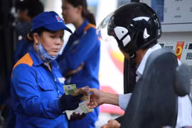 Nhân viên Petrolimex đang bán xăng cho khách hàng. (Ảnh: Đức Duy/Vietnam+)