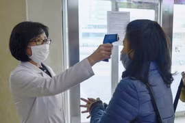 Người dân được kiểm tra thân nhiệt trước khi vào một nhà tắm công cộng do lo ngại dịch COVID-19 ở Bình Nhưỡng, Triều Tiên ngày 18/2/2020. (Ảnh: Kyodo/TTXVN)