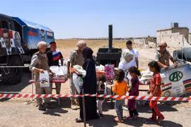 Phát hàng cứu trợ cho người dân Syria ở Abu Duhur, tỉnh Idlib. (Ảnh: AFP/TTXVN)