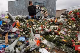 Một nhân viên của một cửa hàng hoa tiêu hủy những bông hoa chưa bán ở Saint Petersburg. (Nguồn: channelnewsasia.com)
