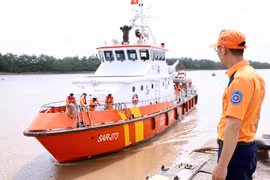 Lực lượng cứu hộ đưa thuyền viên bị nạn của tàu cá TH 90282 TS về bờ. (Ảnh: Trần Hoàng Ngọc/TTXVN)