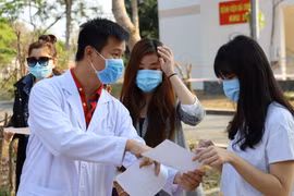 Bác sỹ Bệnh viện dã chiến Củ Chi hướng dẫn và căn dặn bệnh nhân tự cách ly tại nhà sau xuất viện. (Ảnh: Đinh Hằng/TTXVN)