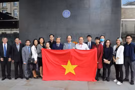 Cán bộ, nhân viên Đại sứ quán Việt Nam tại Vương Quốc Anh, các cơ quan đại diện của Việt Nam, đại diện hội người Việt Nam tại Anh, hội sinh viên Việt Nam tại Anh chụp ảnh bên biển lưu niệm Chủ tịch Hồ Chí Minh tại tòa nhà New Zealand. (Ảnh: Đình Thư/TTXVN