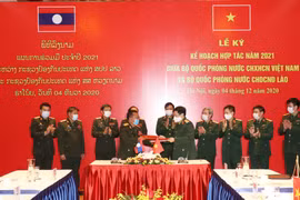 Bộ trưởng Bộ Quốc phòng Ngô Xuân Lịch và Bộ trưởng Bộ Quốc phòng Lào Chansamone Chanyalath trao đổi Kế hoạch hợp tác năm 2021 giữa Bộ Quốc phòng hai nước. (Ảnh: Hồng Pha/TTXVN phát)