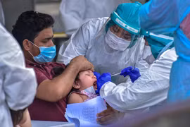 Nhân viên y tế lấy mẫu dịch xét nghiệm COVID-19 cho trẻ em tại Kuala Lumpur, Malaysia. Đường cong dịch bệnh ở nước này "đã được làm phẳng." (Ảnh: THX/TTXVN)