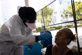 Nhân viên y tế lấy mẫu dịch xét nghiệm COVID-19 cho người dân tại Miami, bang Florida, Mỹ ngày 16/4/2020. (Ảnh: AFP/TTXVN)