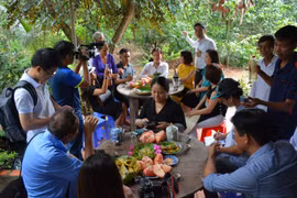 Khách du lịch thưởng thức các món ăn chế biến từ bưởi ở Cồn Hô. (Nguồn: dulichtravinh.com.vn)