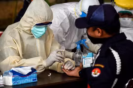 Nhân viên y tế lấy mẫu xét nghiệm nhanh COVID-19 tại một chợ ở Banten, Indonesia, ngày 21/4/2020. (Ảnh: THX/TTXVN)