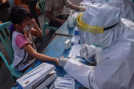 Nhân viên y tế lấymẫu máu xét nghiệm nhanh COVID-19 cho trẻ em tại Surabaya, Đông Java, Indonesia ngày 13/5/2020. (Ảnh: THX/TTXVN)