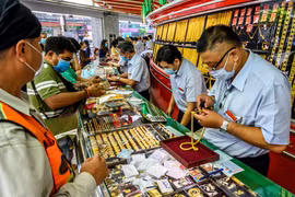 Người dân mua bán vàng tại một cửa hàng ở Bangkok, Thái Lan. (Ảnh: AFP/TTXVN)