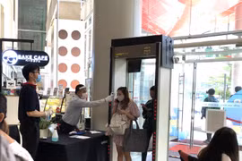 Nhân viên của một trung tâm thương mại ở thủ đô Bangkok kiểm tra thân nhiệt của người vào tòa nhà. (Ảnh: Ngọc Quang/TTXVN)