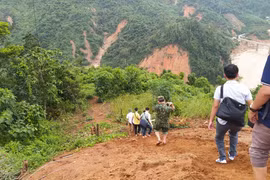 Lực lượng cứu hộ băng rừng Phước Lộc để tiếp cận xã Phước Sơn. (Ảnh: Quốc Dũng/TTXVN)