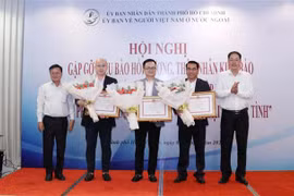Ông Nguyễn Thành Trung (ngoài cùng bên phải), Phó Chủ tịch Ủy ban MTTQ Việt Nam Thành phố và ông Võ Thành Chất (ngoài cùng bên trái), Phó Chủ nhiệm Ủy ban về Người Việt Nam ở nước ngoài Thành phố, trao Bằng khen của UBND Thành phố cho 3 kiều bào có những 