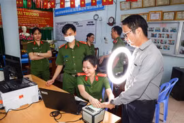 Cán bộ Công an phường Tân An, quận Ninh Kiều hướng dẫn người dân thực hiện đăng ký tài khoản định danh điện tử mức độ 2. (Ảnh: TTXVN phát)