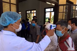 Hành khách đi trên những phương tiện giao thông tiến hành kiểm tra thân nhiệt, khai báo y tế tại chốt kiểm tra thị xã Hương Thủy, tỉnh Thừa Thiên-Huế. (Ảnh: Đỗ Trưởng/TTXVN)