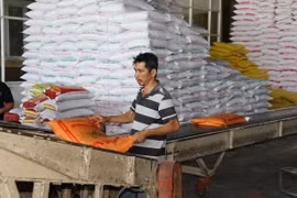 Đóng gói gạo tại cơ sở lau bóng gạo Giàu Thanh Hoàng ở chợ gạo Bà Đắc-An Cư (Cái Bè, Tiền Giang). (Ảnh: Hữu Chí/TTXVN)