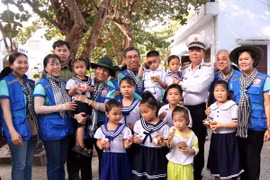 Chuẩn Đô đốc Phạm Như Xuân, Phó Tư lệnh Hải quân cùng Phó Bí thư Thành ủy Thành phố Hồ Chí Minh Nguyễn Phước Lộc và thiếu nhi trên đảo Trường Sa lớn. (Ảnh: Xuân Khu/TTXVN)