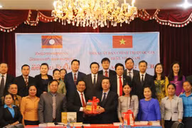 Phó giáo sư, tiến sỹ Vũ Trọng Lâm, Phó Giám đốc, Phó Tổng Biên tập Nhà xuất bản Chính trị quốc gia Sự thật (phải) trao tặng sách lý luận chính trị dịch sang tiếng Lào cho Bộ Thông tin, Văn hóa và du lịch Lào. (Ảnh: Xuân Tú/TTXVN)