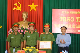 Chủ tịch UBND tỉnh Đồng Tháp Nguyễn Văn Dương trao thưởng cho 1 tập thể và các cá nhân có thành tích xuất sắc trong phá án. (Ảnh: Chương Đài/TTXVN