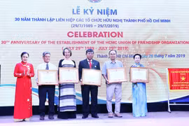 Bà Nguyễn Phương Nga, Chủ tịch Liên hiệp các tổ chức hữu nghị Việt Nam (VUFO - ngoài cùng bên trái) trao tặng Bằng khen của VUFO cho đại diện một số tổ chức thuộc Liên hiệp các tổ chức hữu nghị Thành phố Hồ Chí Minh. (Ảnh: Xuân Khu/TTXVN)