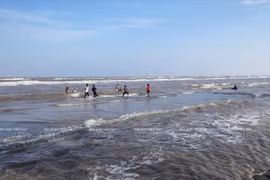Du khách vui đùa và tắm biển ở bãi tắm thuộc Khu du lịch biển Ba Động. (Ảnh: Nguyễn Luân/Báo ảnh Việt Nam)