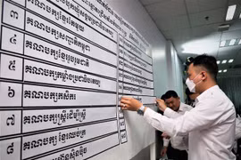 Nhân viên NEC niêm yết kết quả xếp thứ tự 18 chính đảng tham gia tổng tuyển cử năm 2023. (Ảnh: Huỳnh Thảo/ TTXVN)