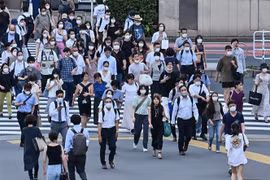 Người dân di chuyển trên phố ở Tokyo, Nhật Bản. (Ảnh: AFP/TTXVN)