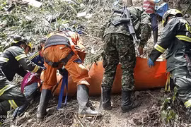 Nhân viên cứu hộ và cảnh sát chuyển nạn nhân trong vụ tai nạn xe buýt ở Santander, Colombia, ngày 22/7/2023. (Ảnh: AFP/TTXVN)