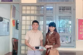 Anh Khánh trao trả tài sản nhặt được cho chị Vân. (Ảnh: TTXVN phát)