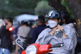 Nhiệt độ giảm, nhiều người phải mặc thêm áo. (Ảnh: Hoàng Hiếu/TTXVN)