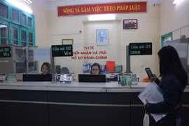 Người dân thực hiện các thủ tục hành chính tại bộ phận "Một cửa" phường Quán Thánh, quận Ba Đình. (Ảnh Mạnh Khánh/TTXVN)