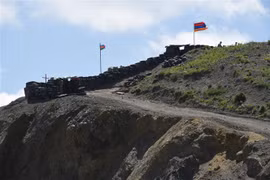 Quốc kỳ Azerbaijan (trái) và quốc kỳ Armenia tại trạm kiểm soát biên giới giữa hai nước ở làng Sotk (Armenia). (Ảnh: AFP/TTXVN)
