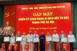 Phó Bí thư Thành ủy Hàn Nội Ngô Thị Thanh Hằng trao bằng khen cho các cá nhân là các chiến sỹ cách mạnh bị địch bắt tù đày. (Ảnh: Nguyễn Thị Tuyết Mai/TTXVN)