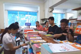 Cách phụ huynh đi tìm sách lớp Một cho con sáng 9/7. (Ảnh: PM/Vietnam+)