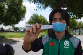 Đối tác tài xế của Gojek hào hứng khoe kết quả âm tính khi xét nghiệm nhanh COVID-19. (Ảnh: T.U/Vietnam+)