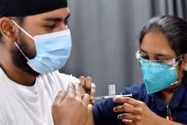 Nhân viên y tế tiêm vaccine phòng COVID-19 cho người dân tại Sydney, Australia. (Ảnh: AFP/TTXVN)
