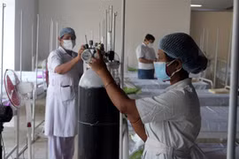 Nhân viên y tế chuẩn bị bình ôxy cho bệnh nhân COVID-19 tại Kolkata, Ấn Độ. (Ảnh: THX/TTXVN) 