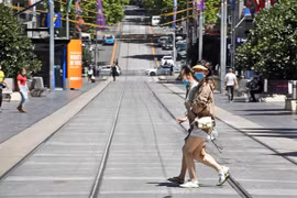 Người dân đeo khẩu trang phòng dịch COVID-19 khi di chuyển trên phố ở Melbourne, bang Victoria, Australia ngày 9/11/2020. (Nguồn: AFP/TTXVN) 