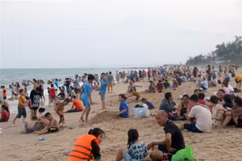 Bãi biển Đồi Dương (thành phố Phan Thiết) đông người dân và du khách trong ngày nghỉ lễ đầu tiên. (Ảnh: Nguyễn Thanh/TTXVN)
