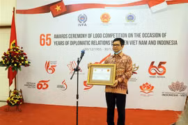 Vụ trưởng Vụ Đông Nam Á, Bộ Ngoại giao Indonesia Denny Abdi trao tượng trưng giải khuyến khích của cuộc thi. (Ảnh: Hữu Chiến/TTXVN) 