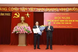 Thứ trưởng Bộ Kế hoạch và Đầu tư Nguyễn Duy Đông (trái) nhận quyết định của Ban Bí thư giữ chức Phó Bí thư Tỉnh ủy Vĩnh Phúc nhiệm kỳ 2020-2025. (Ảnh: Hoàng Hùng/TTXVN)