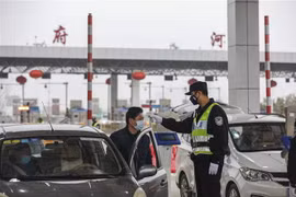 Kiểm tra thân nhiệt của lái xe trên tuyến đường cao tốc ở Vũ Hán, tỉnh Hồ Bắc, Trung Quốc, ngày 24/1. (Nguồn: AFP/TTXVN) 