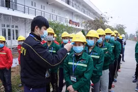 Công nhân, cán bộ thi công đều được kiểm tra thân nhiệt, xét nghiệm trước khi vào công trường Bệnh viện dã chiến số 3 của Hải Dương. (Ảnh: TTXVN phát) 