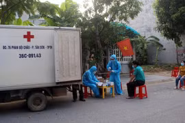Cán bộ y tế lấy mẫu để xét nghiệm sàng lọc SARS-CoV-2 ở Thanh Hóa. (Ảnh: Nguyễn Nam/TTXVN) 