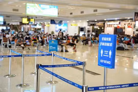 Chăng dây, và biển thông báo để hành khách giữ khoảng cách tối thiểu 2m khi làm thủ tục hàng không. (Nguồn: TTXVN phát) 