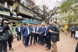 Bí thư Thành ủy Hà Nội Đinh Tiến Dũng trao đổi với các đồng chí lãnh đạo về công tác chỉ đạo, triển khai cải tạo, xây dựng lại chung cư cũ trên địa bàn quận Đống Đa. (Ảnh: Tuyết Mai/TTXVN)