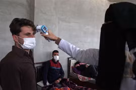 Nhân viên y tế kiểm tra thân nhiệt nhằm ngăn chặn sự lây lan của dịch COVID-19 tại Idlib, Syria, ngày 27/4/2020. (Nguồn: AFP/TTXVN) 