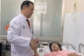 Tiến sỹ, bác sỹ Ngô Đức Hiệp, Trưởng Khoa Phỏng-Phẫu thuật tạo hình, động viên người bị nạn. (Ảnh: Đinh Hằng/TTXVN)